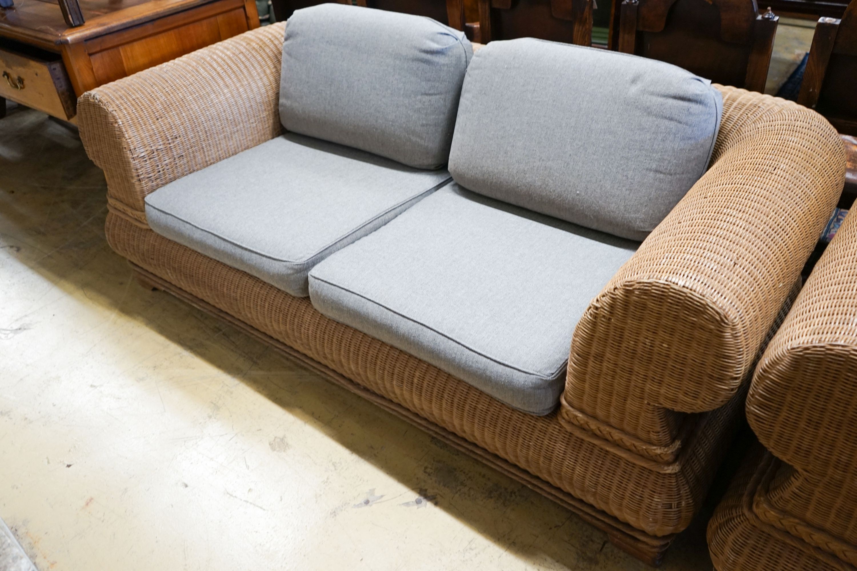 A pair of contemporary rattan conservatory settees, with grey fabric cushions, seats and backs, length 190cm, depth 100cm, height 70cm
